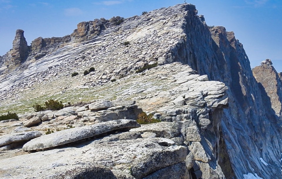 Man standing near top of mountain peak