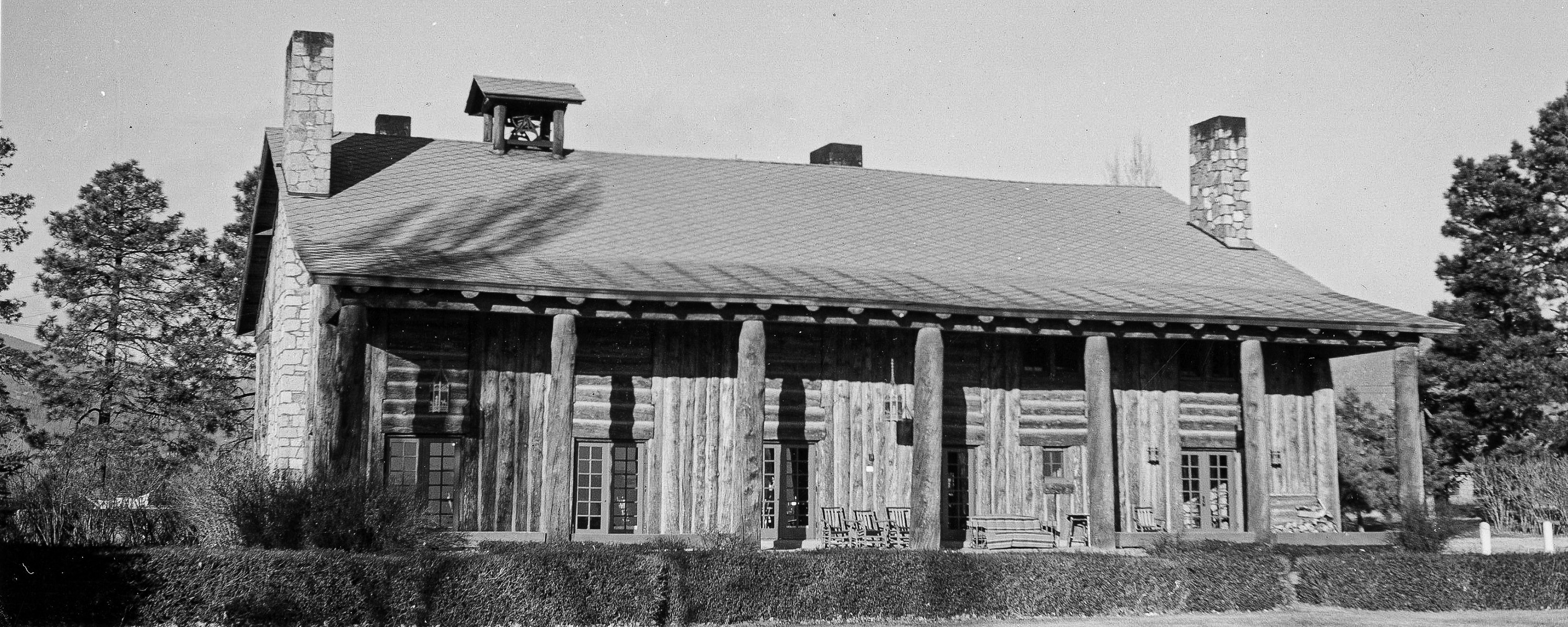 A black and white photo of children playing ice hockey on a pond.