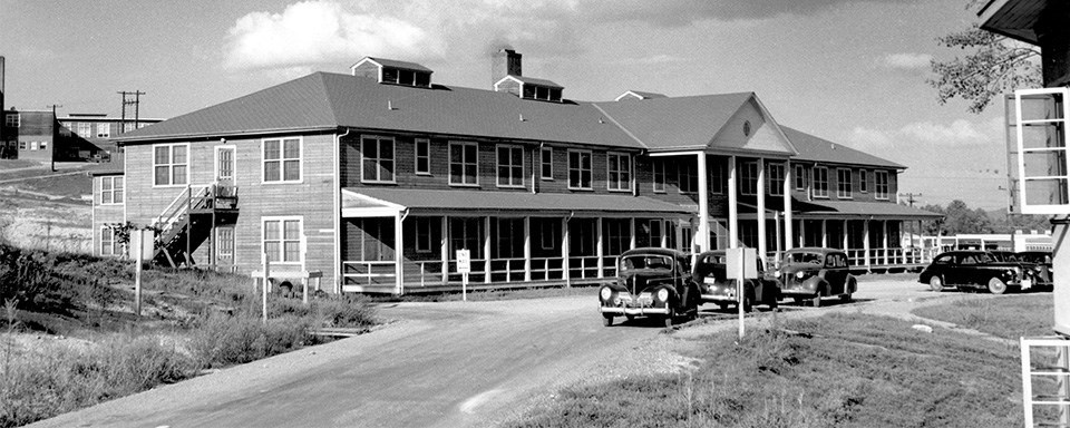 A black and white photo of a two-story building with many windows.