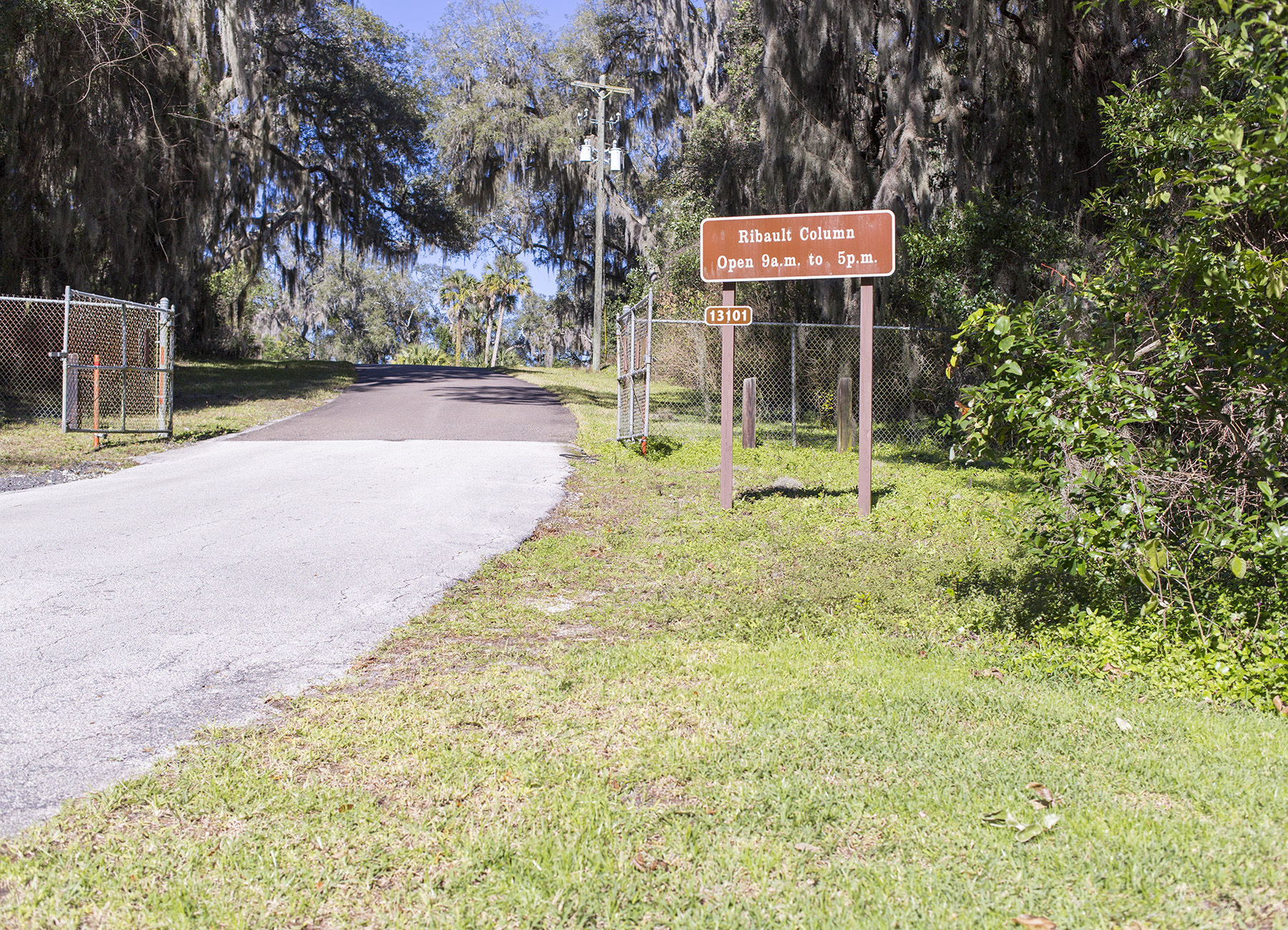 gate make of chain link fence with brown sign