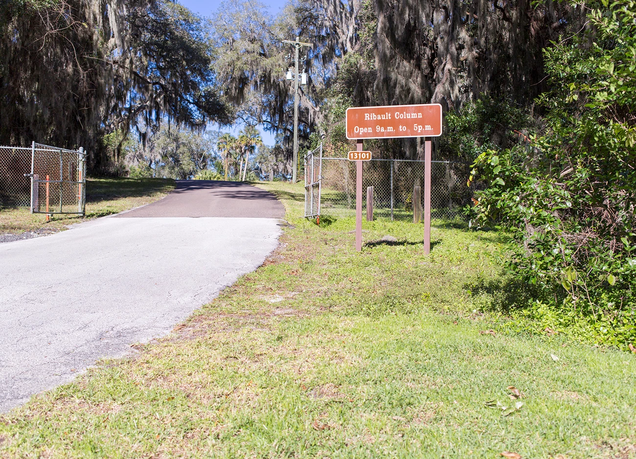 gate make of chain link fence with brown sign
