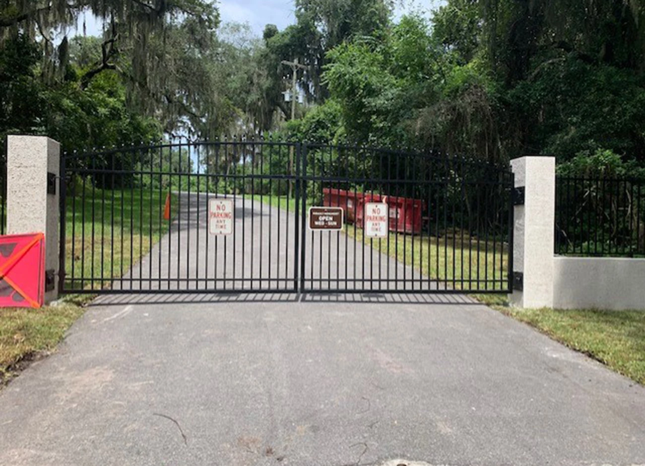 gate make of chain link fence with brown sign