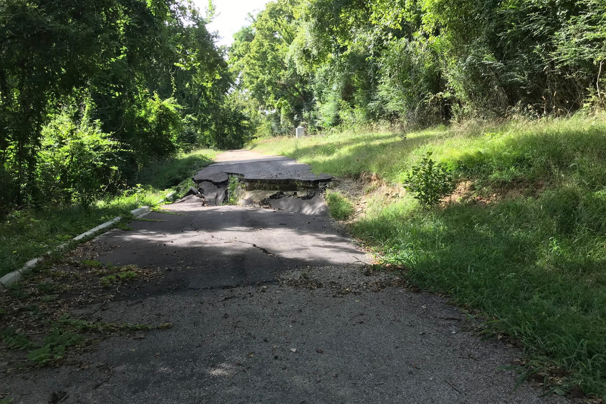 North Union Avenue before repairs, showing severely cracked, buckled, and collapsed pavement along a section of the roadway.