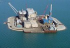 aerial view of a tiny island covered entirely in cranes and buildings