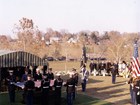 Mourners look on as American servicemen fold a flag over a coffin.