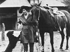Lillian Erickson Riggs standing between a dog and a horse at Faraway Ranch