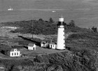 A black and white historic photo of the Destruction Island lighthouse tower on a bluff top.