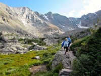 Two backpackers trek along an alpine trail