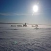 People traveling by snowmobile.