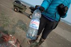 a woman holding a disposable plastic bottle