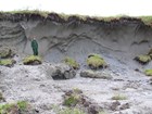 a person standing next to an eroded hillside