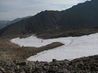 a large patch of snow near the top of a rocky mountain