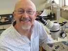 Dr. David Elliott in his lab with a slab of fossils.