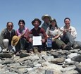 A group of people on top of a mountain peak