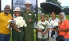 A group of people holding white flowers.