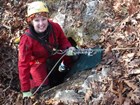 caver rappelling into a cave