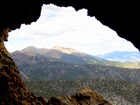 view out of cave opening to distant mountains and trees