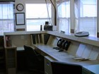 Office with a console desk and many windows looking into a fenced compound