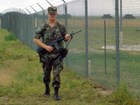A uniformed airman patrols a fence-line