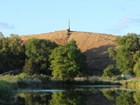 pond with trees and hill in background