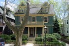 Exterior of a green wood sided house with yellow trim.