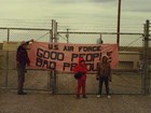 Activists hold a banner at the gate to a missile silo.