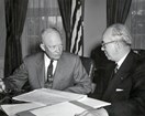 A man briefs President Eisenhower in the Oval Office