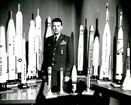 Uniformed air force officer surrounded by missile models