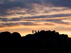 rocks and people silhouetted at sunset