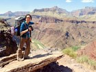 hiker pointing into grand canyon