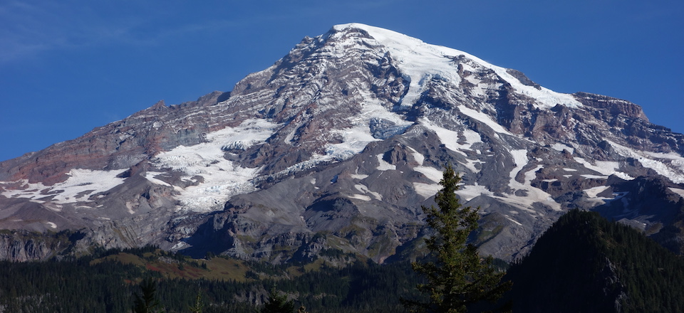 A rocky volcanic peak drapped with glaciers.