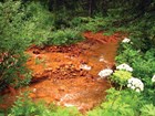 a creek tainted orange due to contaminants. 