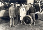 four people near a plane
