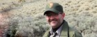 Photo of Tobin Roop smiling in ranger attire. 