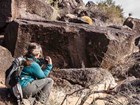 person looking closely at rock art