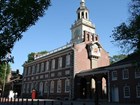 Color photo of a two story, red brick building with bell tower and adjacent wing building.