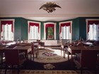 Color photo of a room with desks and chairs facing a central dias.