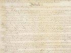 Image of handwritten U.S. Constitution showing dark ink on parchment-colored paper.