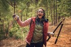 A trail volunteer clearing foliage