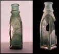 A cloudy glass bottle with cracks and a few pieces missing. 