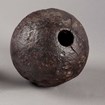 A pocked metal ball with a hole drilled in the side. 