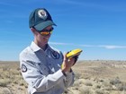person outdoors recording data on a hand held instrument