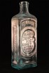 Large medicine bottle, rectangular with embossed sides.
