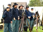 Several men dressed as soldiers standing with guns
