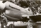 Black and white photo of two men in uniform with an airplane 