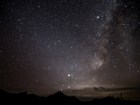 A sky filled with stars towers over the desert landscape.