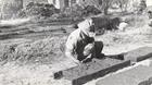 historic photo of man in cowboy hat putting mud in an adobe frame