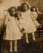 Two young girls holding dolls