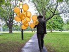 a park ranger walking through a park with balloons 