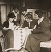 Women sewing stars onto a flag